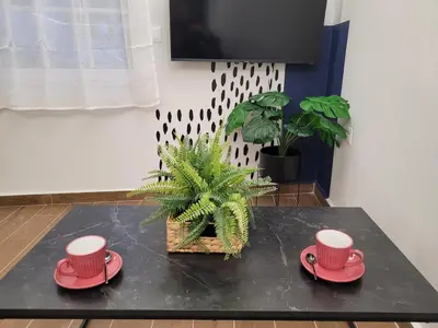 a coffee table with two red cups and a plant at Hyacinthus city apartment in Rhodes Town