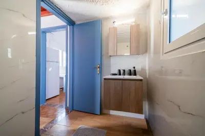 a bathroom with a blue door and a sink at Aelia Filoxenia Cottage in Afantou