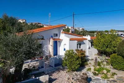 a white house with an orange roof at Aelia Filoxenia Cottage in Afantou