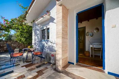 a patio with chairs and a table next to a house at Aelia Filoxenia Cottage in Afantou