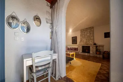 a living room with a table and a fireplace at Aelia Filoxenia Cottage in Afantou