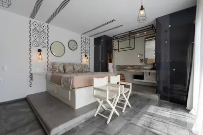 a bedroom with a bed and a table and chairs at K Studios in Faliraki