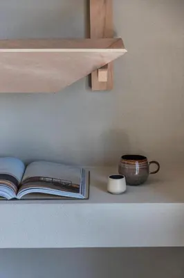a book on a shelf with a cup and a bowl at K Studios in Faliraki