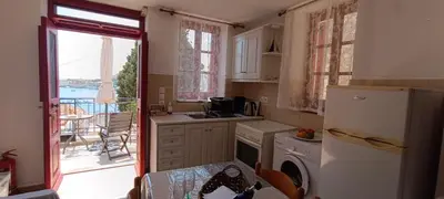 a kitchen with a refrigerator and a table and a balcony at Elena Studio in Halki