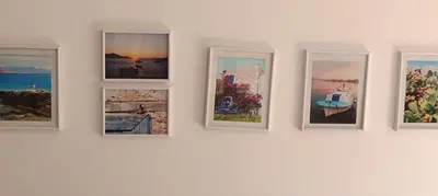 a group of pictures on a wall in a gallery at Elena Studio in Halki