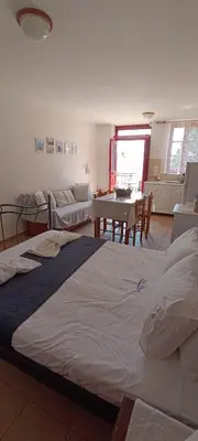 a bedroom with a large bed and a dining room at Elena Studio in Halki