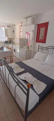 a large bed in a room with a kitchen at Elena Studio in Halki
