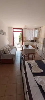 a living room with two beds and a table at Elena Studio in Halki