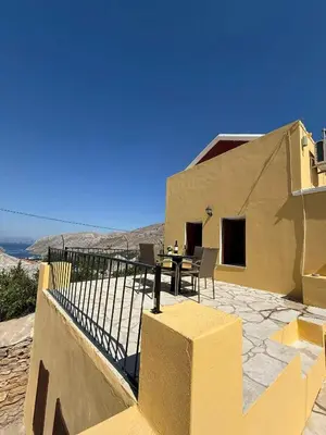 a house with a table and chairs on a patio at Maria's Dream House in Symi