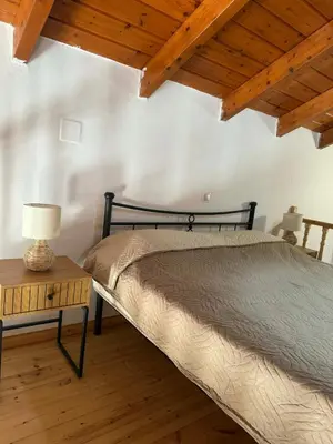 a bedroom with a bed and a table with a lamp at Maria's Dream House in Symi
