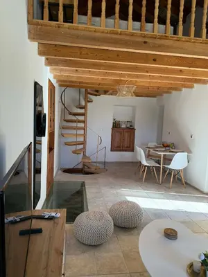 a living room with a table and a wooden ceiling at Maria's Dream House in Symi