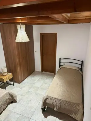 a bedroom with a bed and a chandelier at Maria's Dream House in Symi
