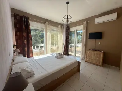 a bedroom with a bed and a large window at Casa Fountain Villa in Kolimbia
