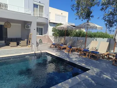 a swimming pool with chairs and a house at Casa Fountain Villa in Kolimbia
