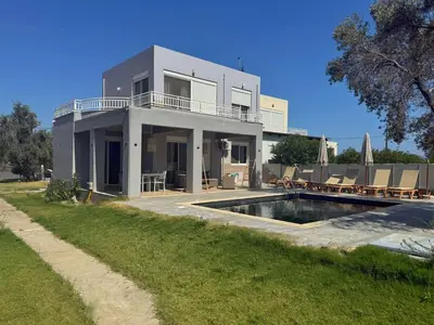 a house with a swimming pool in front of it at Casa Fountain Villa in Kolimbia