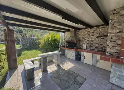 an outdoor kitchen with a table and a stone wall at Casa Fountain Villa in Kolimbia