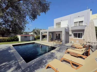 a villa with a swimming pool and patio furniture at Casa Fountain Villa in Kolimbia