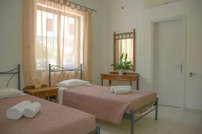 a bedroom with two beds and a mirror at Palm Residence l - Islander's Home Collection in Rhodes Town