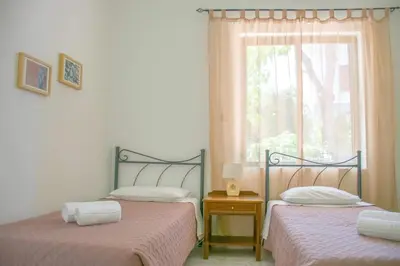 two twin beds in a room with a window at Palm Residence l - Islander's Home Collection in Rhodes Town