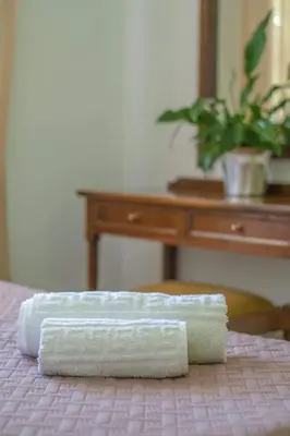 a stack of towels on a bed with a desk at Palm Residence l - Islander's Home Collection in Rhodes Town