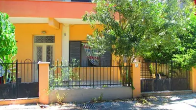 a yellow house with a black fence in front of it at Palm Residence ll - Islander's Home Collection in Rhodes Town