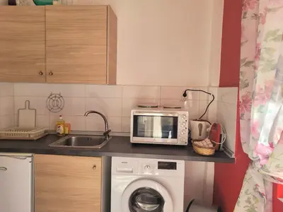 a kitchen with a microwave and a washing machine at Palm Residence ll - Islander's Home Collection in Rhodes Town