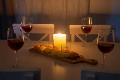 a table with two glasses of wine and a plate of food at maison de rivière in Afantou