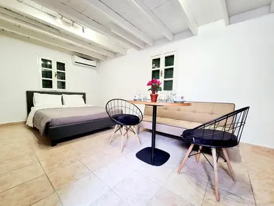a bedroom with a bed and a table and chairs at Piccolo Modern Suites - Old Town in Rhodes Town