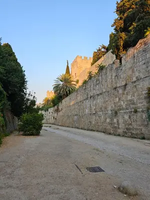 an old stone wall next to a street at Piccolo Modern Suites - Old Town in Rhodes Town