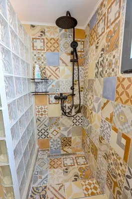 a bathroom with a tiled floor and a shower at Anastazia Apartments - Rhodes City in Rhodes Town