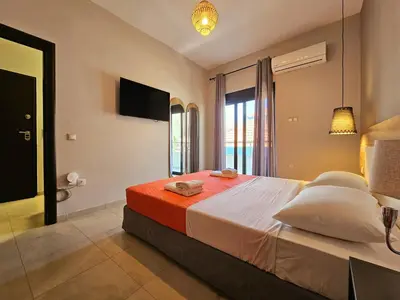 a bedroom with a large bed and a television at Anastazia Apartments - Rhodes City in Rhodes Town