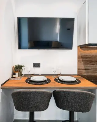 a kitchen with a counter with two plates and two chairs at Aelios Petra sea view apartment 3 in Asgourou