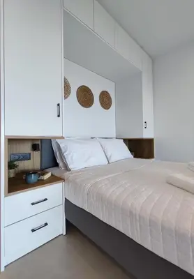 a bedroom with a white bed and a white cabinet at Aelios Petra sea view apartment 3 in Asgourou