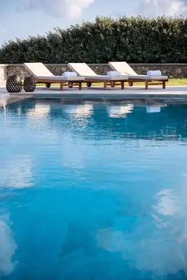 a swimming pool with two lounging chairs and a pool at Villa Salamina in Lachania