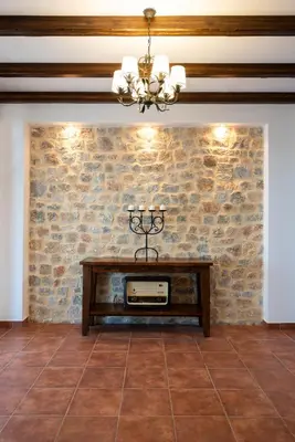 a dining room with a stone wall and a table at Villa Salamina in Lachania