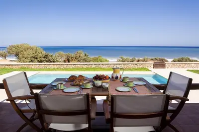 a table with food on it next to a pool at Villa Salamina in Lachania