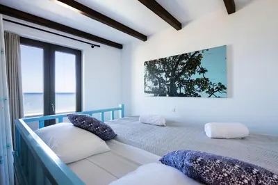 a bedroom with two beds and a large window at Villa Salamina in Lachania