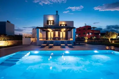 a swimming pool in front of a house at night at Villa Salamina in Lachania