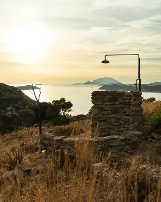 an old stone wall with a street light and the ocean at Dawn To Dusk Sea and Mountain View in Kamiros