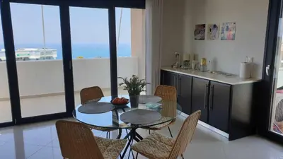 a dining room with a table and chairs in a kitchen at Sea View Apartment in Rhodes Town