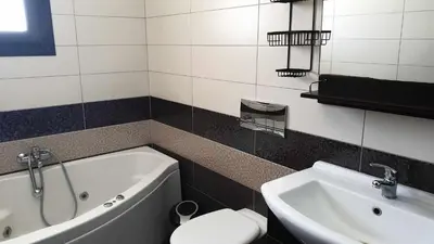 a bathroom with a tub and a toilet and a sink at Sea View Apartment in Rhodes Town