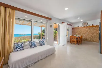 a bedroom with a bed and a view of the ocean at The Rhodes South Escape Beach in Plimmiri
