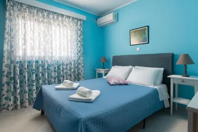 a blue bedroom with a bed with towels on it at The Rhodes South Escape Beach in Plimmiri
