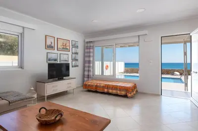 a living room with a television and views of the ocean at The Rhodes South Escape Beach in Plimmiri