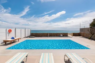 a swimming pool with a view of the ocean at The Rhodes South Escape Beach in Plimmiri