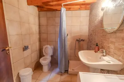 a bathroom with a toilet and a sink and a shower at Maison Lemonia in Lardos