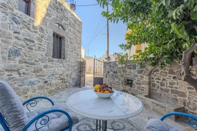 a table with a bowl of fruit on a patio at Maison Lemonia in Lardos