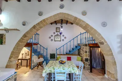 a dining room with an archway in a house at Maison Lemonia in Lardos