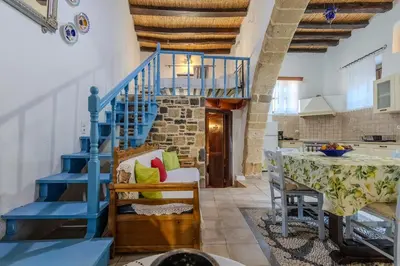 a blue staircase in a living room with a table at Maison Lemonia in Lardos