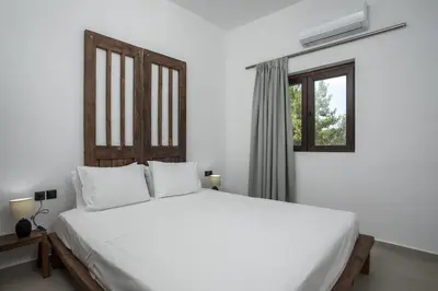 a bedroom with a large white bed and a window at Zàia Suites & Living, Suite N2, pool view in Gennadi
